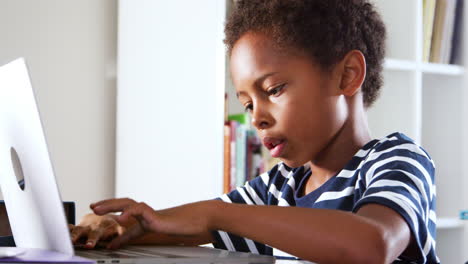 Kleiner-Junge-Sitzt-Am-Schreibtisch-Im-Schlafzimmer-Und-Benutzt-Einen-Laptop