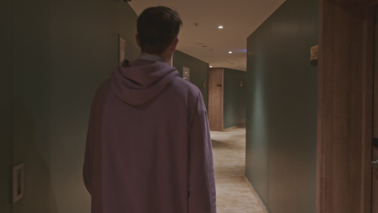 호텔 복도를 걸어가는 남자
