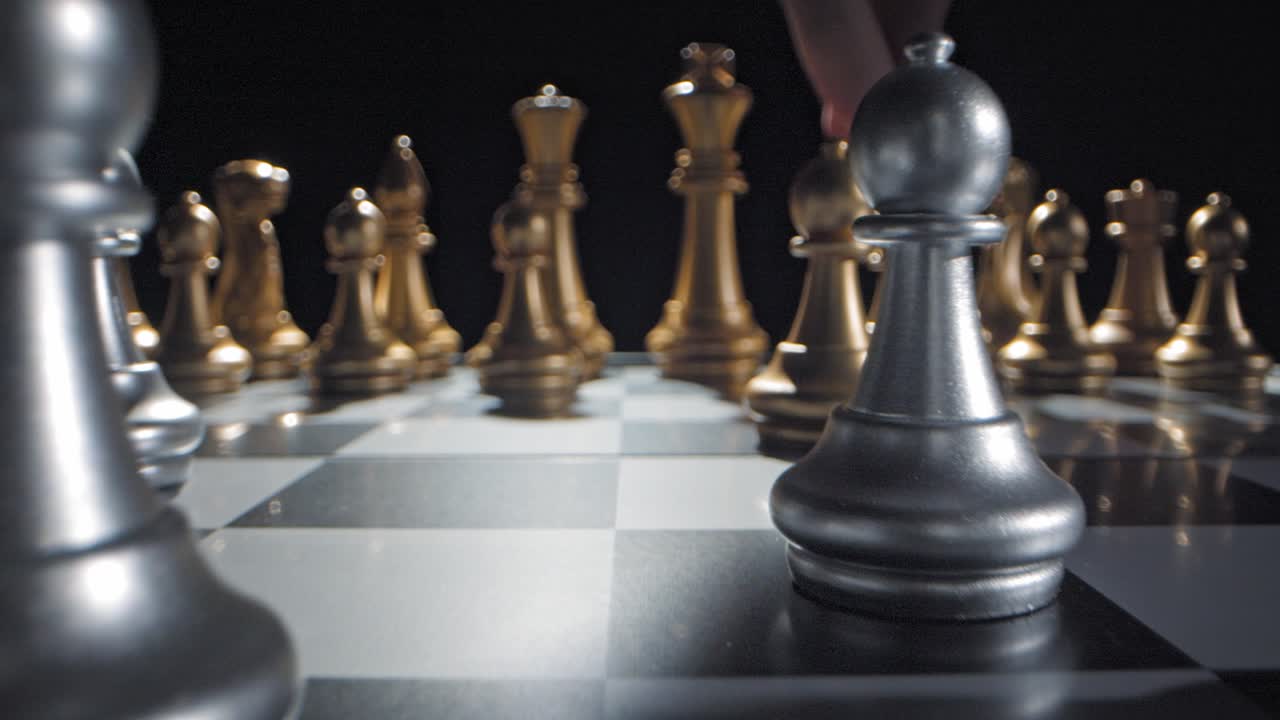 Gold bishop moved forward during chess game, low angle dolly in