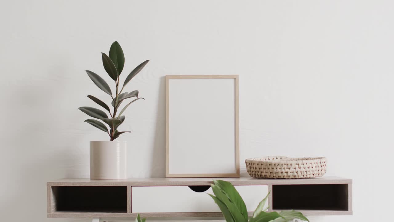 marco de madera con espacio de copia en fondo blanco con planta en el escritorio contra la pared blanca