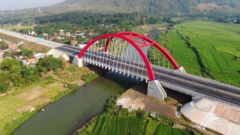 red arch construction of kalikuto bridge in central java landscape