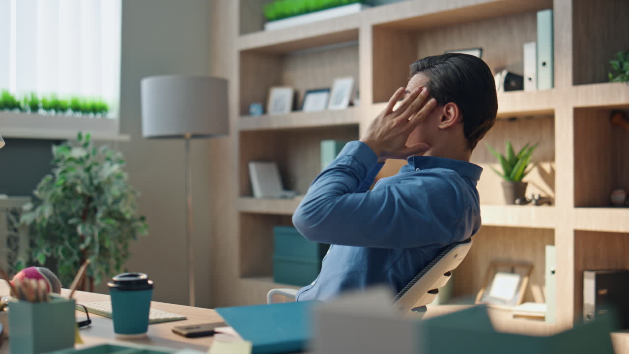 스트레스를 받은 직원이 사무실에서 머리를 마사지하고, 두통이 난 남자가 이를 마사지한다.