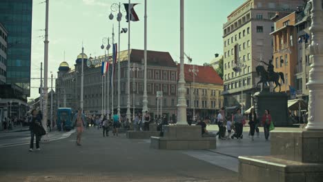 crowds walk through josip jelačić square, zagreb, near the equestrian statue of ban jelačić