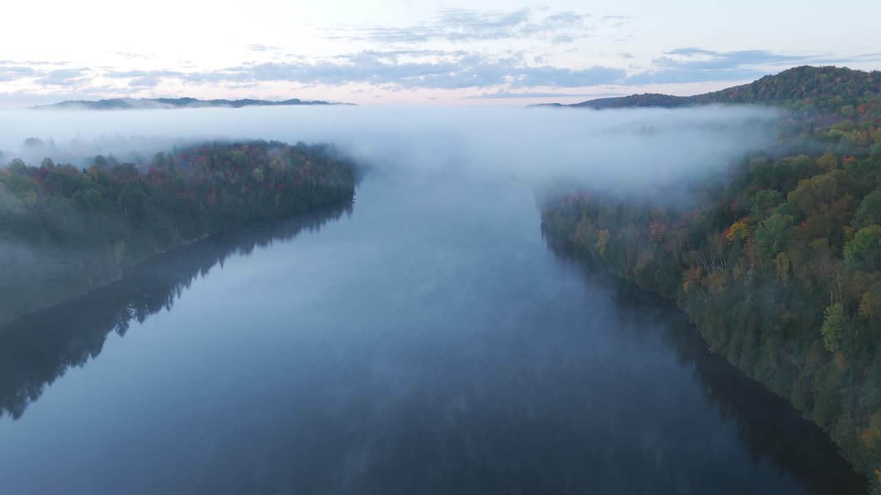 aerial sunsrise foggy mountains landscape with lake, drone fly above the clouds amazing planet earth calming footage