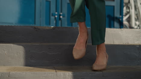 female legs in beige high-heeled shoes go downstairs