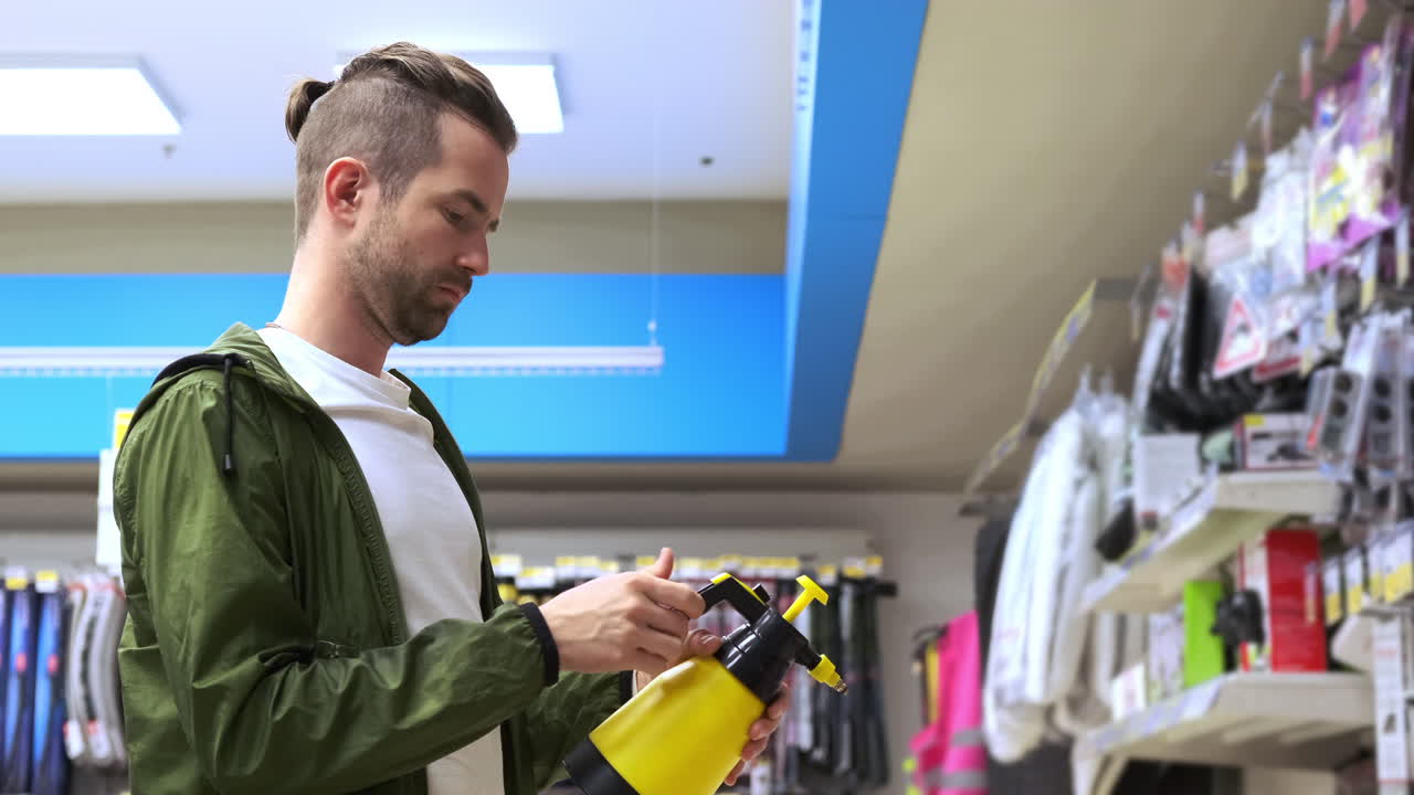 Hombre examinando una botella pulverizadora amarilla en una tienda