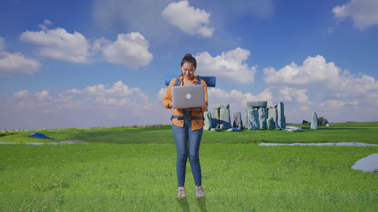 Full Body Of Asian Female Hiker With Mountaineering Backpack Looking At A Laptop And Screaming Goal Celebrating The Success While Traveling In Stonehenge