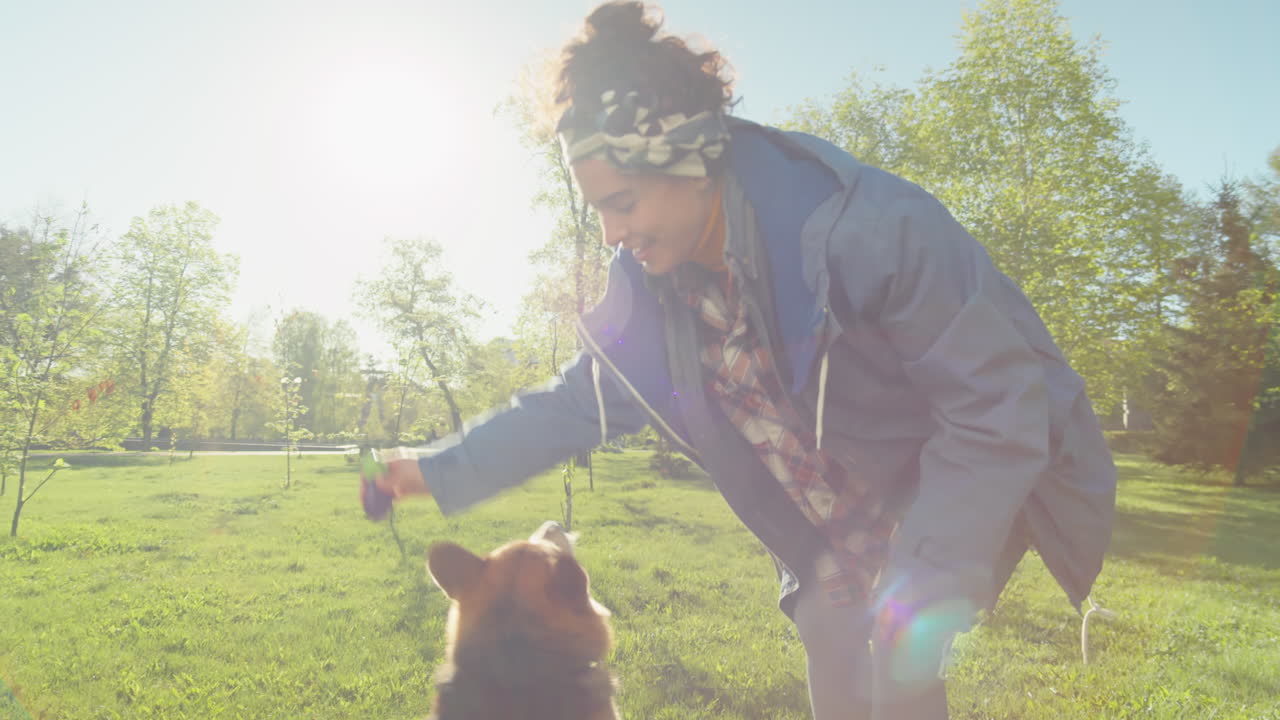 Woman Playing with Her Dog in a Sunny Park