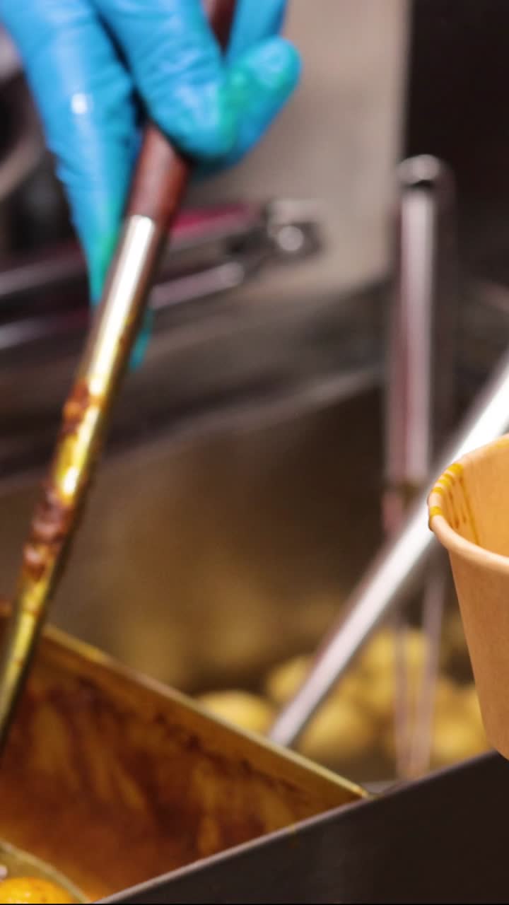 manos con guantes sirviendo albóndigas en un cuenco