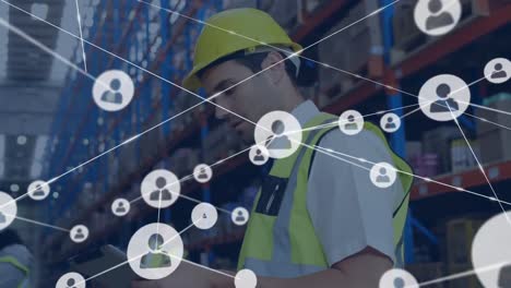 Animation-of-network-of-connections-with-icons-over-caucasian-male-worker-in-warehouse