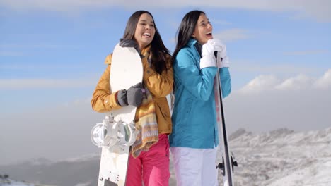 dos mujeres jóvenes con sus snowboards