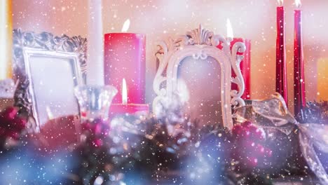 decoración navideña y velas combinadas con la nieve que cae