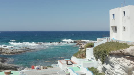 Aerial-Through-Scenic-Little-Greek-Fishing-Village-with-typical-white-Houses-right-at-the-Aegean-Ocean