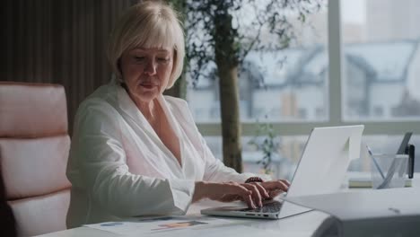 senior woman working on laptop in office