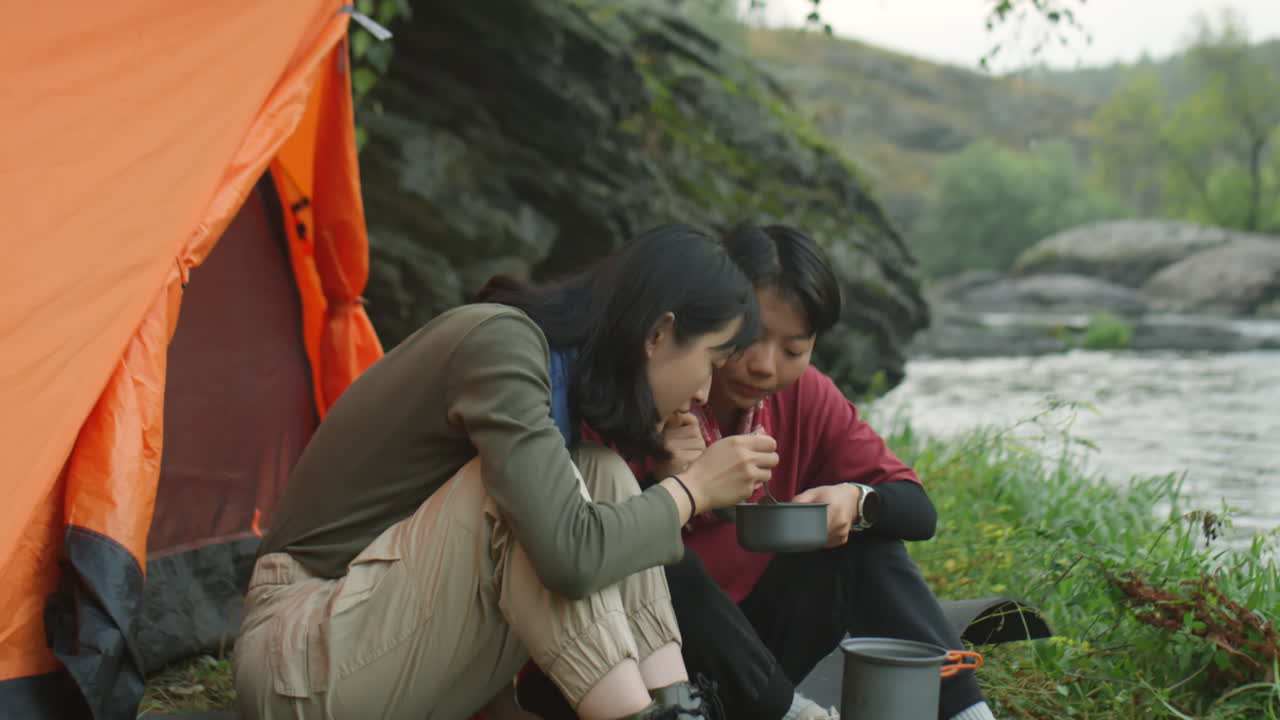 Asian Female Tourists Eating Camping Meal