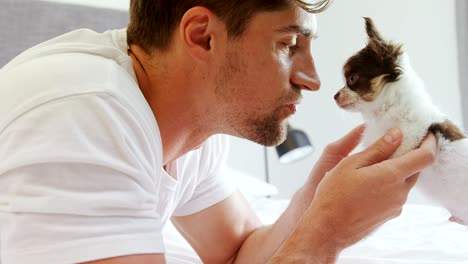 happy young man lying on bed stroking his puppy in the bedroom 4k 4k