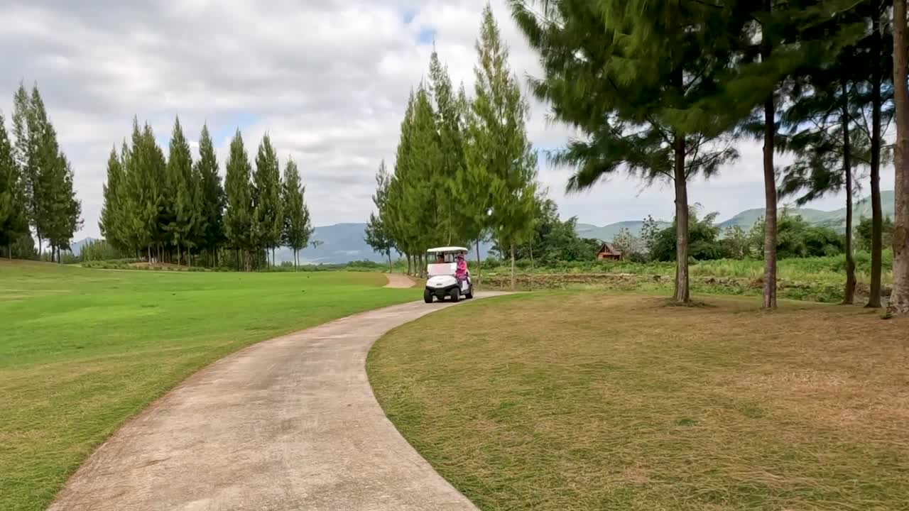 경치 좋은 골프 코스를 가로질러 운전하는 골프 카트