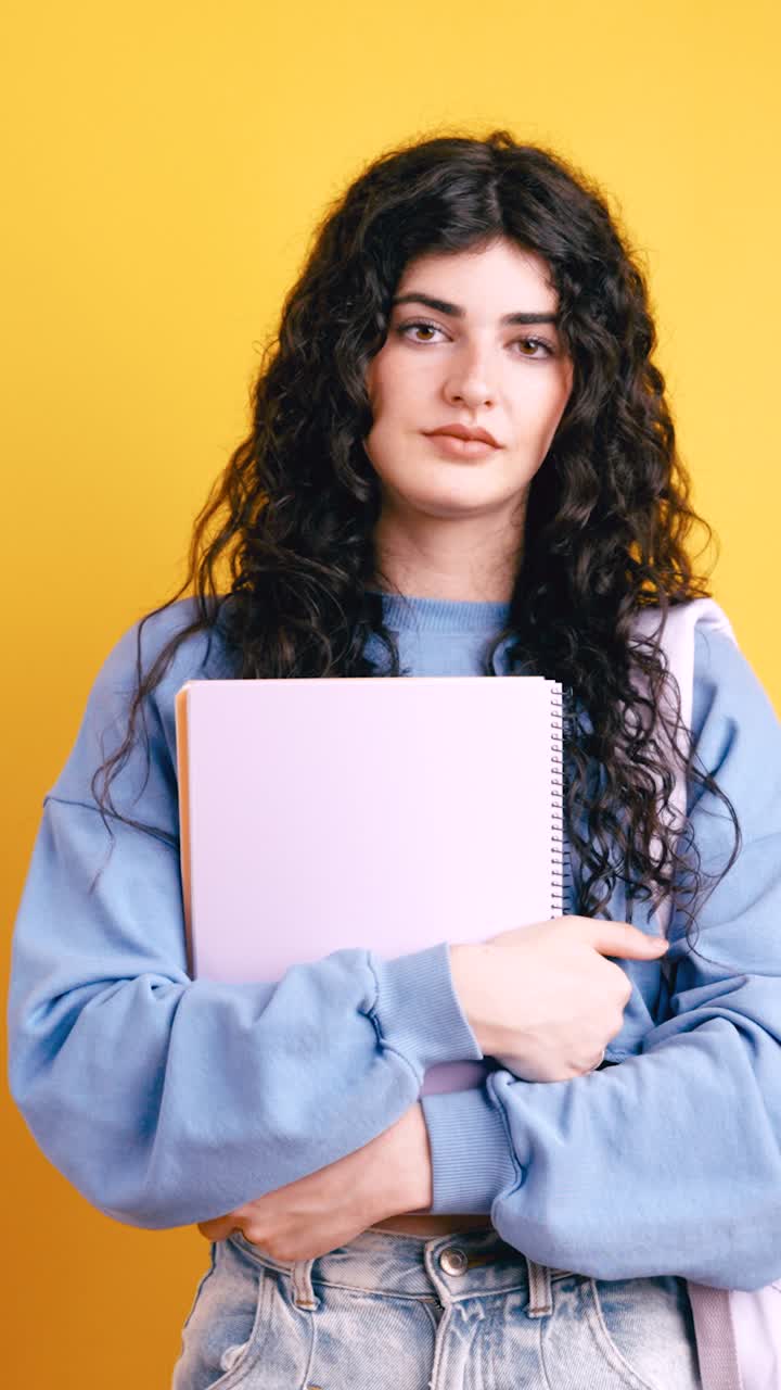 A woman giving a thumbs down while holding a notebook