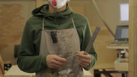 portrait of worker carpenter with respirator in workshop, man in respirator and glasses