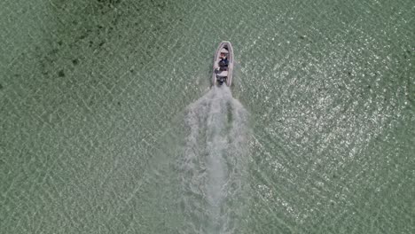 aerial cenital drone shot of a boat in a colorful sea aerial