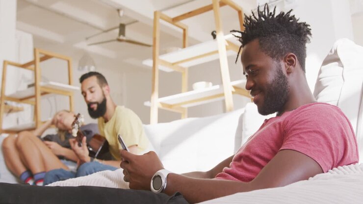 Uomo che sorride mentre usa lo smartphone