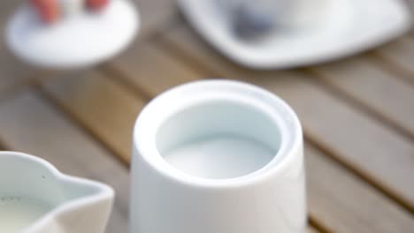 scooping white sugar from jar using teaspoon