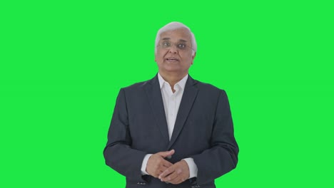 Happy-Indian-senior-journalist-reading-news-Green-screen