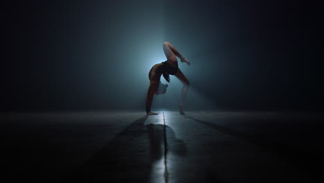 flexible gymnast doing backbend exercises. beautiful woman stretching indoors.