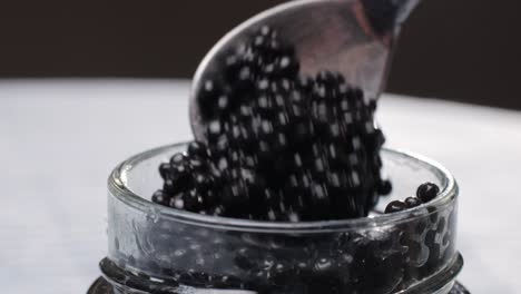 spooning caviar into a jar