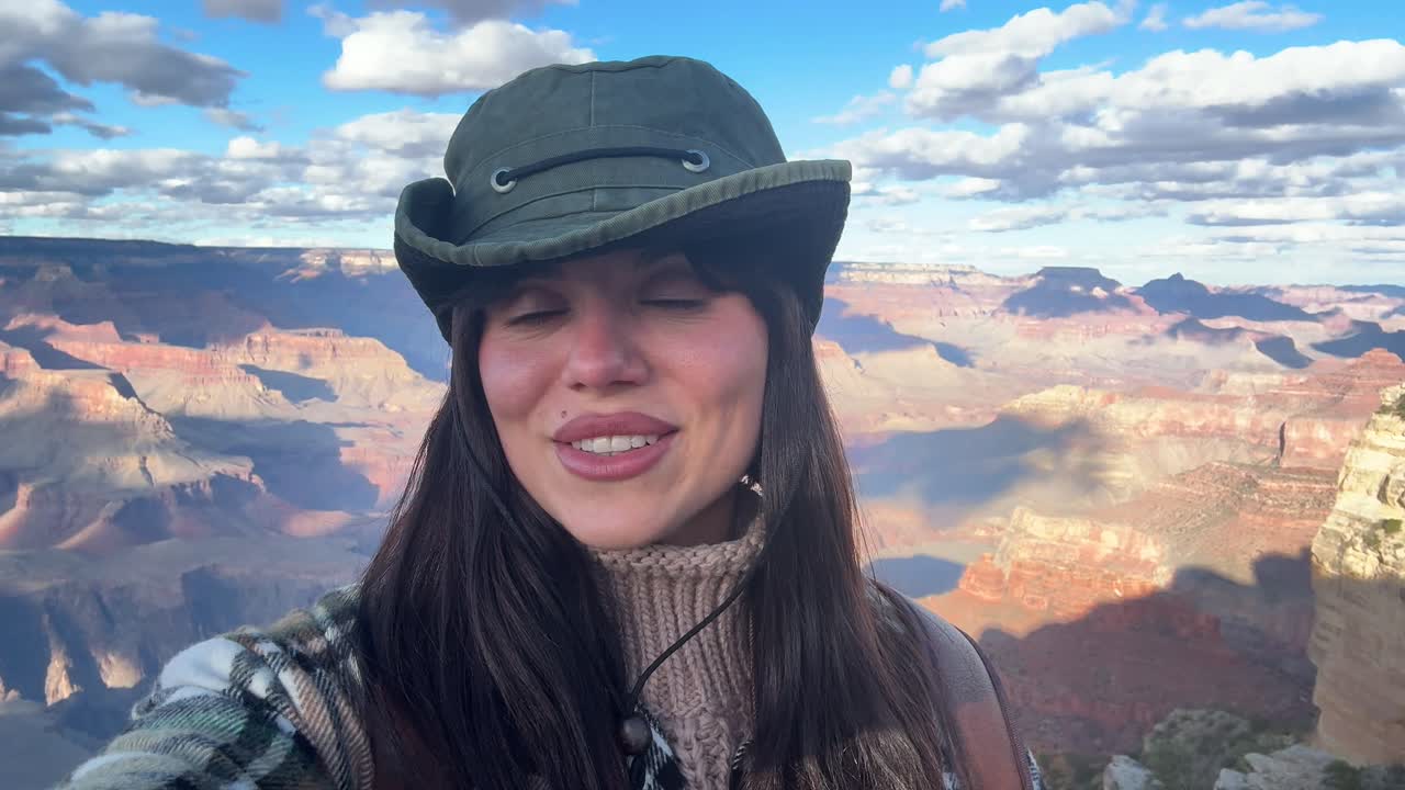 Donna felice che sorride al punto panoramico del Grand Canyon