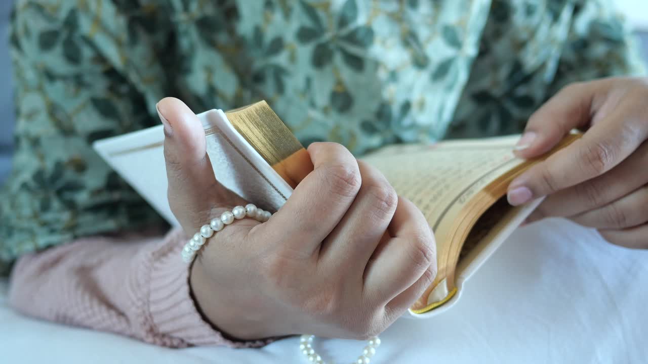 Mano delle donne musulmane che legge il Corano di notte