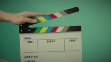 clapperboard hitting. movie film slate. close up hand clapping empty film slate on blue or green screen color background. in and out film slate cutting for video production. film or movie shooting.