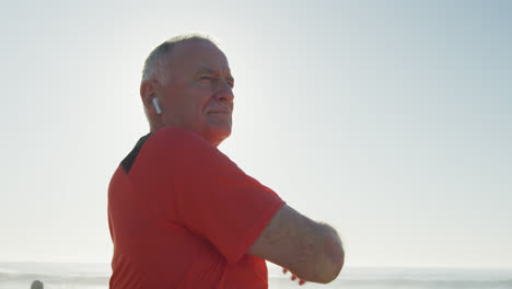 Senior-man-stretching-his-arms-on-the-promenade