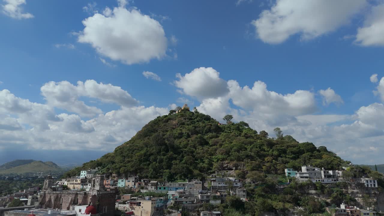 Zooming in on a lush green hill with a forest in Atlixco, Mexico, showcasing nature's beauty.
