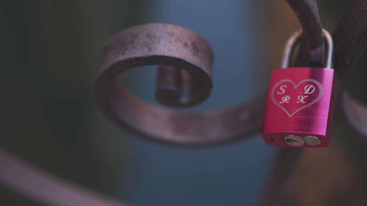Cute red love lock alone attached to a water bridge in Venice.