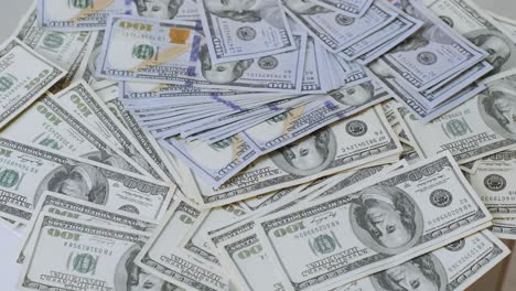 close-up view of piles of 100 us dollar bills arranged in a scattered manner. depicts wealth, finance, savings, or economic themes in high detail.