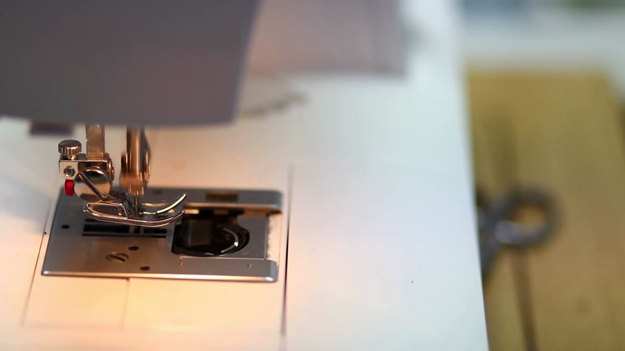Detalje af industrisymaskinens nål, der bevæger sig op og ned i slow motion