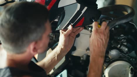 close-up shot: a male mechanic unscrews a bolt that holds an external part of a motorcycle. repair and service bike assessment and repair