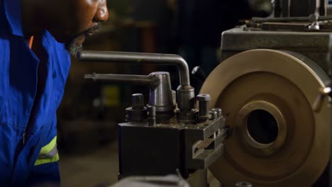 metalúrgico trabajando en una máquina en el taller 4k