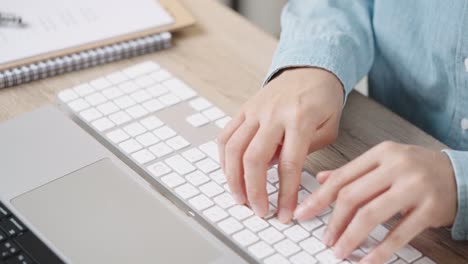 close up hand of a business woman typing keyboard desktop computer on desk office