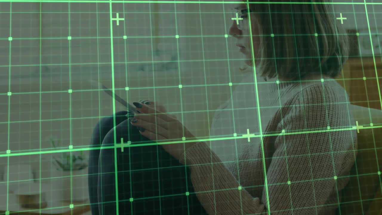 Woman tapping smartphone on sofa with mug initiating digital green grid overlay scanning activity
