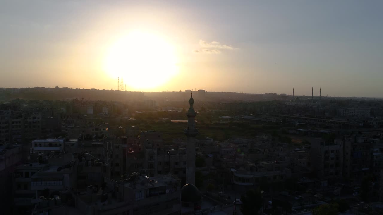 vista aérea con un dron sobre una mezquita siria bajo la puesta de sol. podemos ver la ciudad de alepo en todo el horizonte 4k