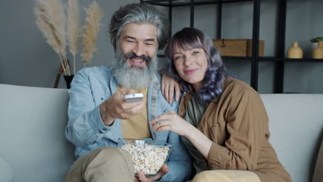 couple enjoying popcorn on the couch