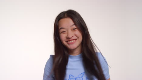 young woman in front of white studio background posing for photo booth style portraits