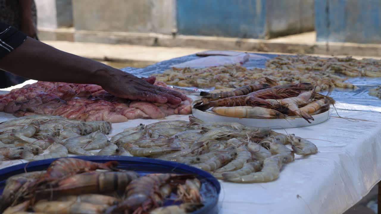muchos mariscos frescos como gambas, camarones y gambas listos para la venta mientras muchas moscas vuelan en el mercado local de pescado al aire libre en negombo, sri lanka