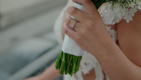 bride holding bouquet with engagement ring close up detail