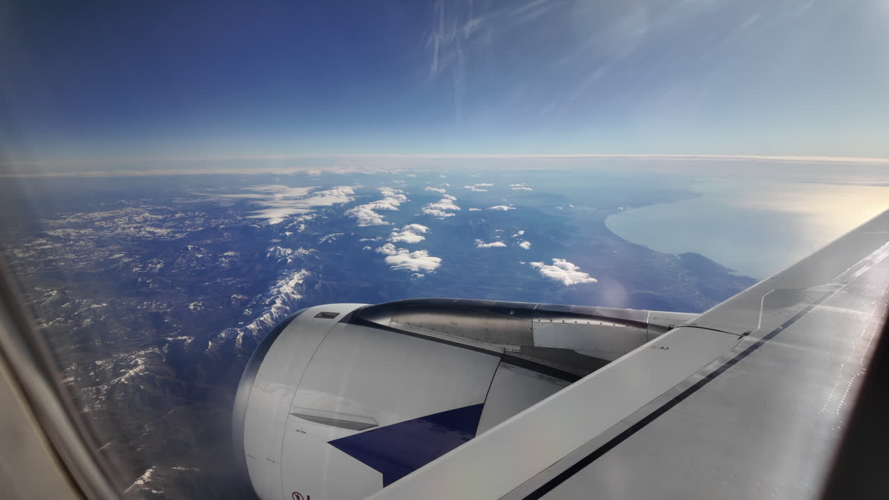 Vista da un finestrino di un aereo su una catena montuosa e il mare
