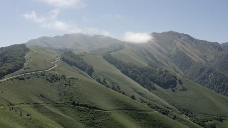 flyover hazy landscape as rustic road follows grassy ridge to horizon