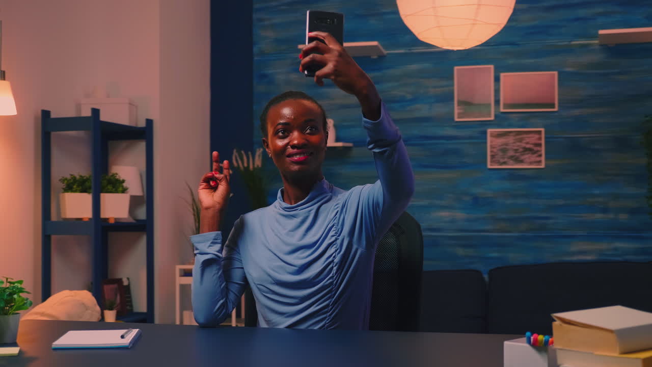 Dipendente africano che si scatta un selfie usando un telefono cellulare e sorridendo alla telecamera