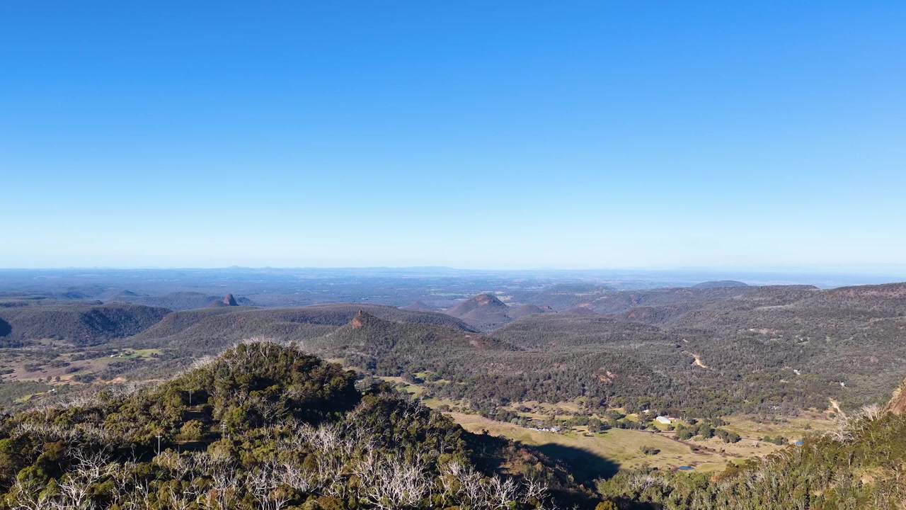 Toma panorámica amplia de cumbres volcánicas bajo un cielo azul despejado en el Parque Nacional Warrumbungle